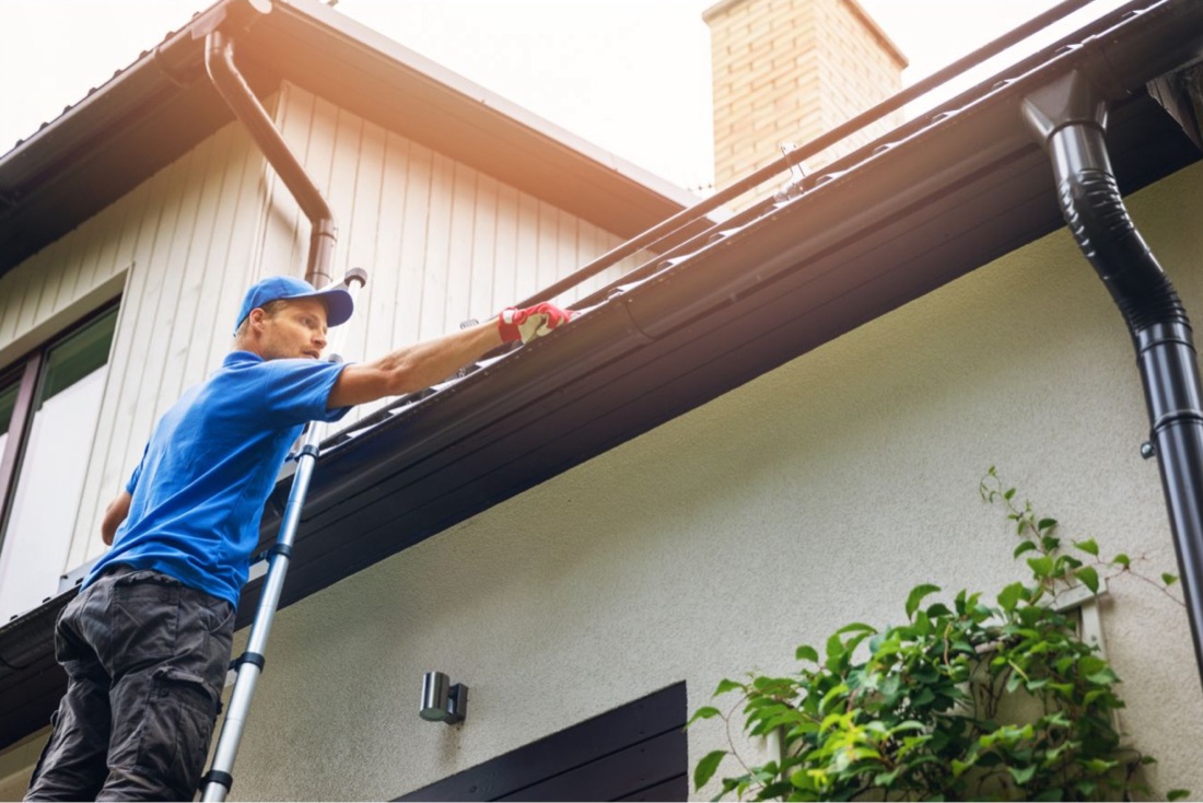 Technician cleaning and servicing gutters in Jacksonville