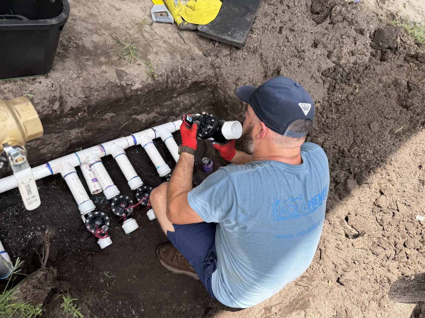 Technician installing a manifold of solenoid valves on an irrigation system in St. Johns County