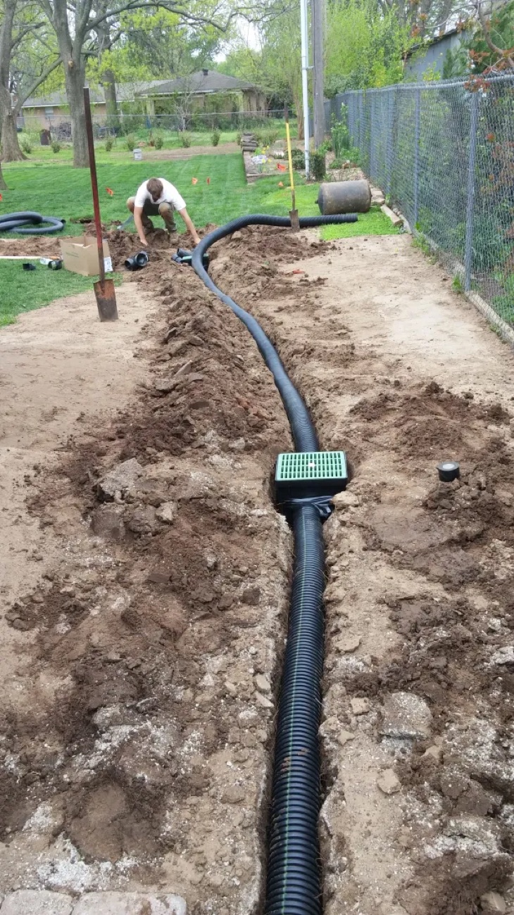New surface drain carrying water away from the home toward a safe outlet